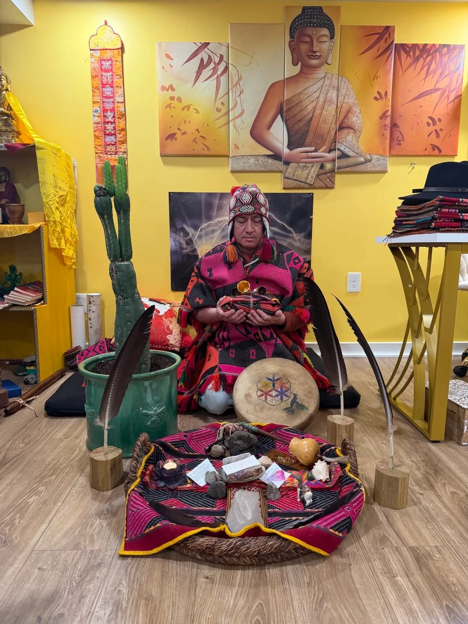 Oswal sitting with ceremonial objects and a tall cactus